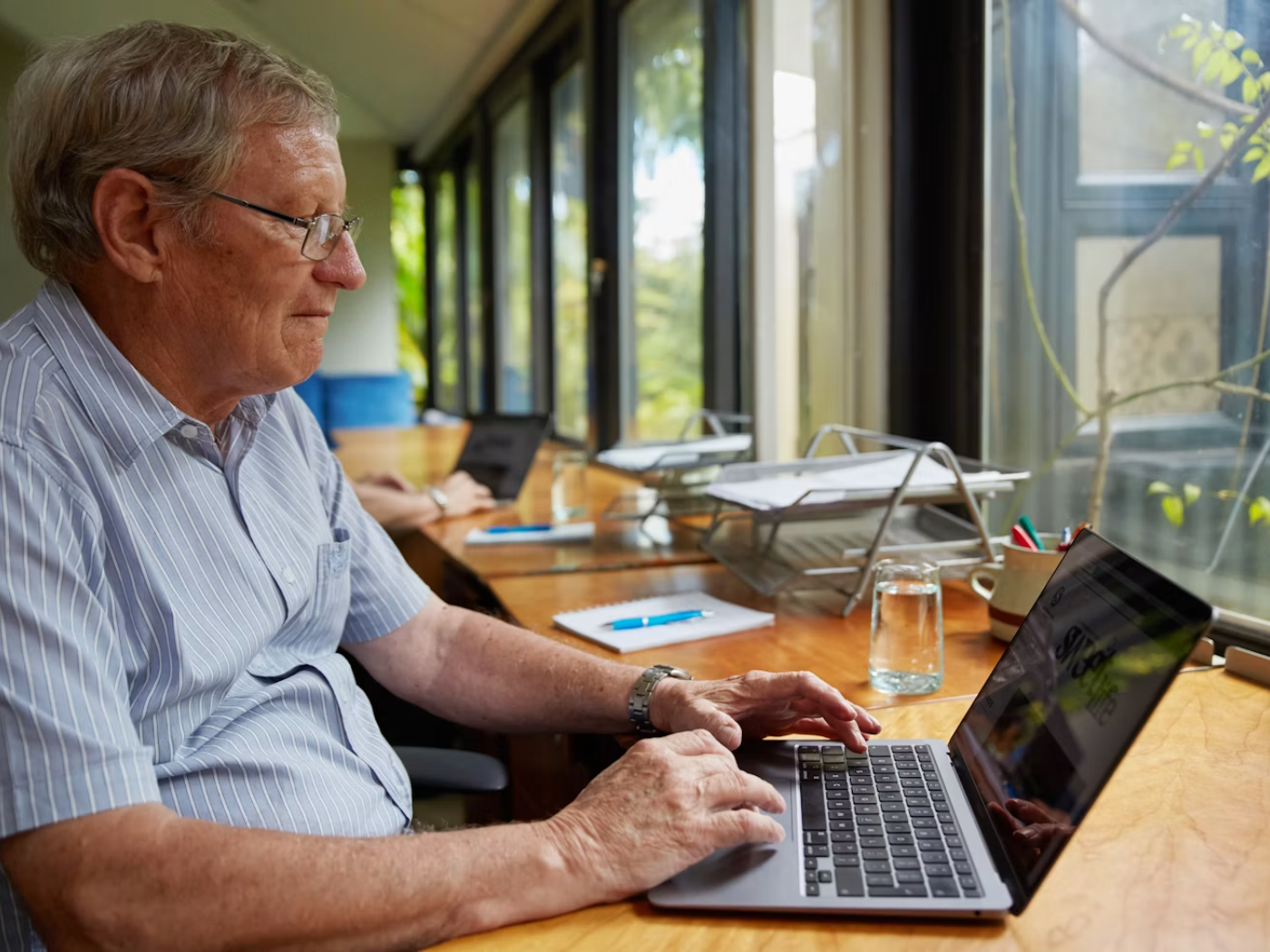 A professional at a desk reviewing work on a laptop