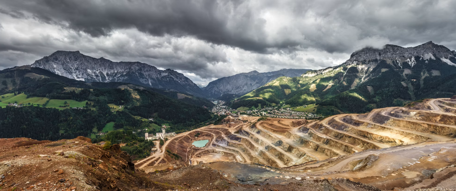 An open-pit mine terraced into a mountain valley